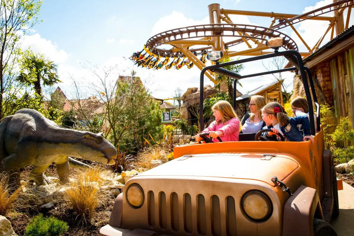 A family in a jeep ride passing dinosaurs in the Lost Kingdom at Paultons Park